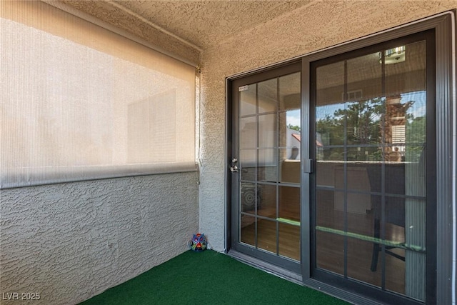 doorway to property featuring stucco siding