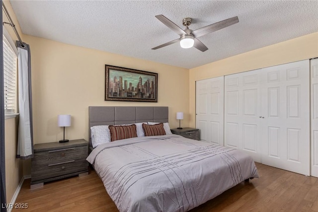 bedroom featuring a textured ceiling, ceiling fan, a closet, and light wood-style floors