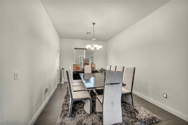 dining space featuring dark wood-style flooring, visible vents, baseboards, and an inviting chandelier