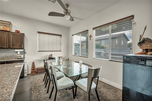 dining area with visible vents, dark wood-type flooring, a ceiling fan, and baseboards