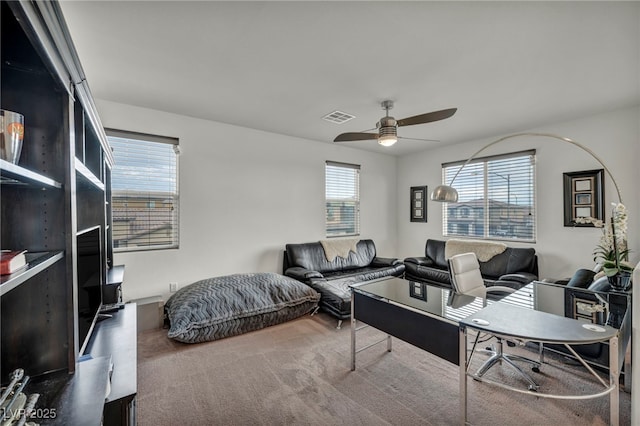 home office featuring carpet flooring, visible vents, and a ceiling fan