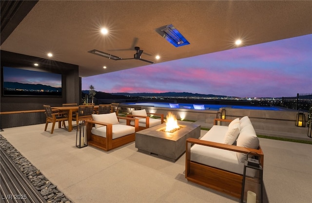 view of patio / terrace with a water view and an outdoor living space with a fire pit