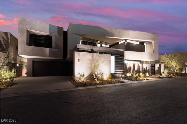 contemporary house featuring driveway, a garage, and stucco siding