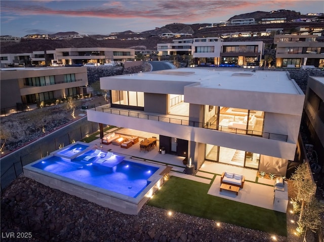 pool at dusk featuring a hot tub, a patio area, an outdoor living space, and a fenced backyard