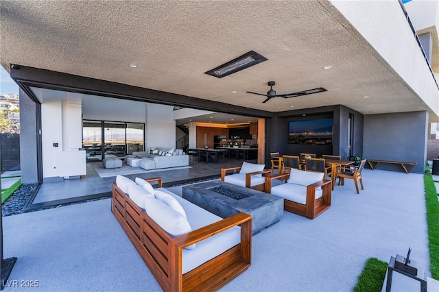 view of patio with outdoor dining space, an outdoor living space with a fire pit, and a ceiling fan