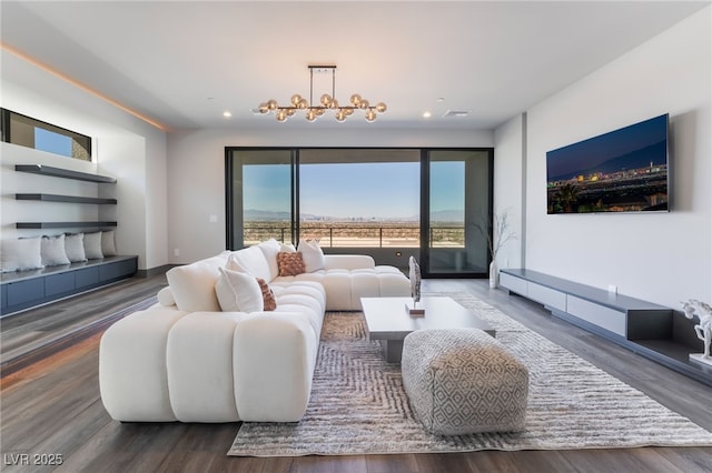 living room with recessed lighting, visible vents, an inviting chandelier, and wood finished floors