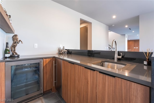 kitchen with recessed lighting, beverage cooler, a sink, brown cabinets, and modern cabinets