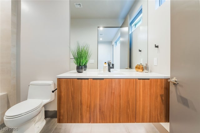 bathroom featuring toilet, visible vents, and vanity