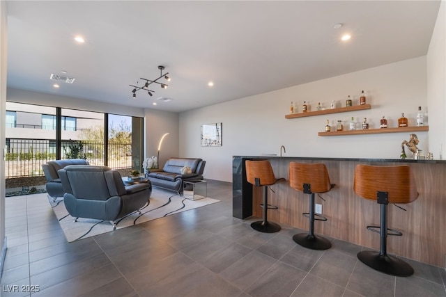 bar with dark tile patterned floors, visible vents, indoor wet bar, and recessed lighting