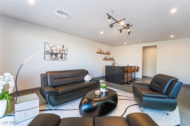 living room featuring baseboards, visible vents, indoor wet bar, and recessed lighting