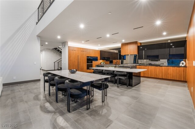 dining room featuring recessed lighting, baseboards, and stairs