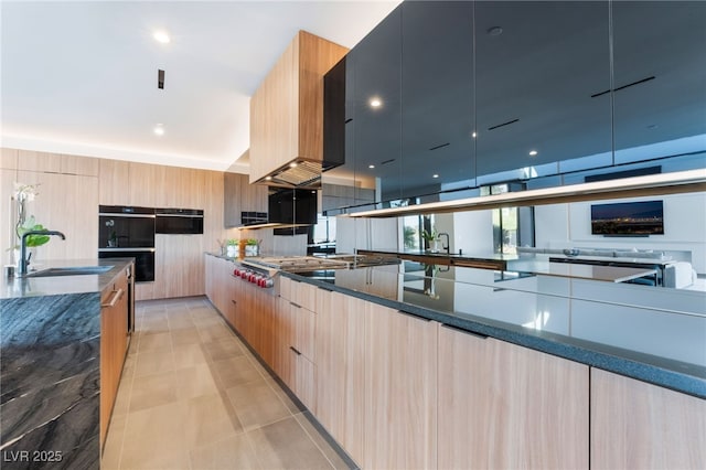 801 Dragons Eye Dr, Henderson, NV 89012 - kitchen with modern cabinets, dark stone counters, stainless steel gas stovetop, light tile patterned floors, and light brown cabinets