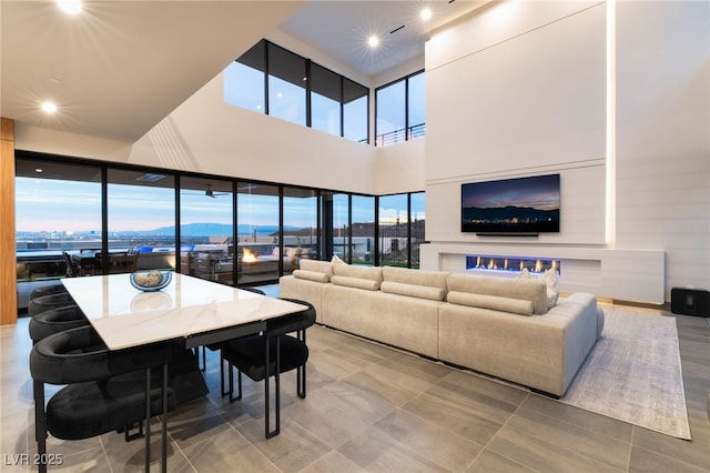 living room featuring a towering ceiling, a wealth of natural light, and recessed lighting