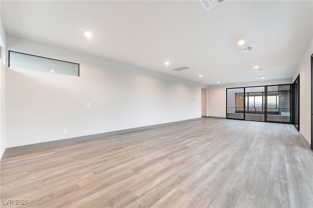 unfurnished room with light wood finished floors, recessed lighting, visible vents, and baseboards