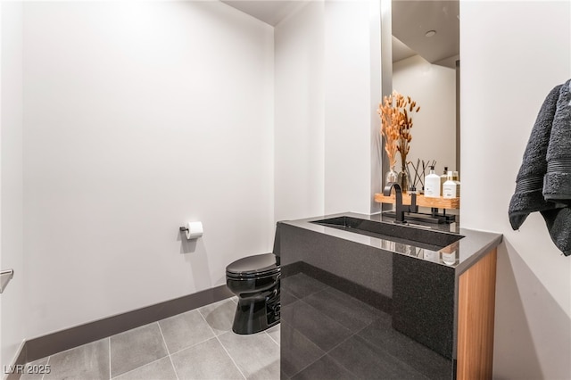 bathroom featuring baseboards, vanity, toilet, and tile patterned floors