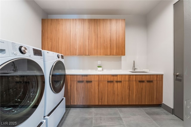 laundry area featuring cabinet space, a sink, washing machine and clothes dryer, and light tile patterned flooring