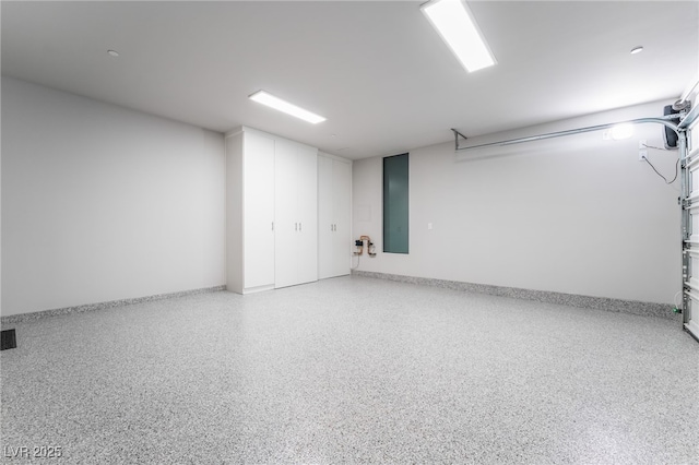 garage featuring baseboards and visible vents