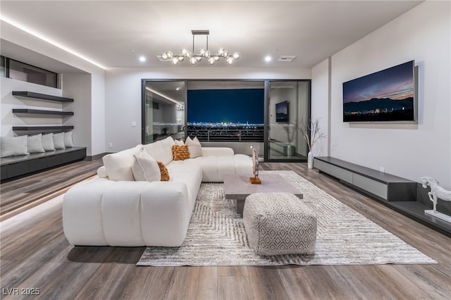 living room featuring recessed lighting, wood finished floors, visible vents, and a notable chandelier