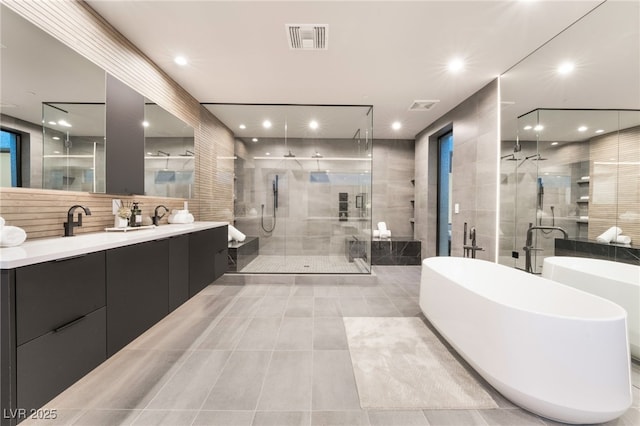 full bath featuring a stall shower, visible vents, a freestanding tub, and vanity