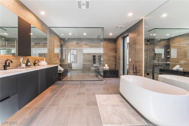 full bath with tile patterned flooring, vanity, visible vents, a freestanding bath, and a shower stall