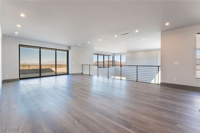 spare room featuring baseboards and wood finished floors