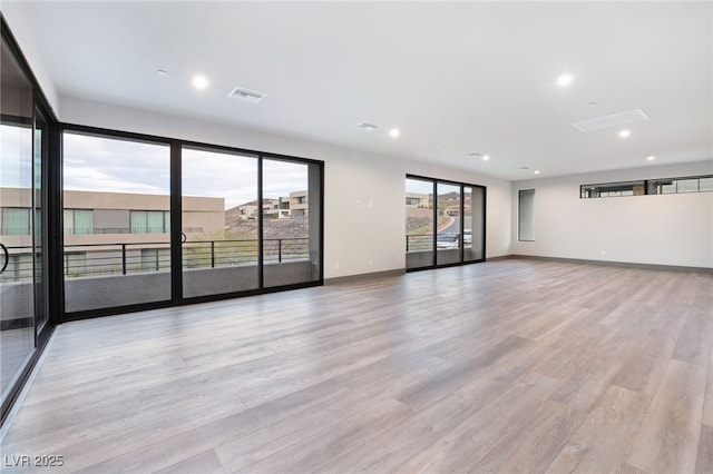 spare room featuring recessed lighting, wood finished floors, visible vents, and baseboards