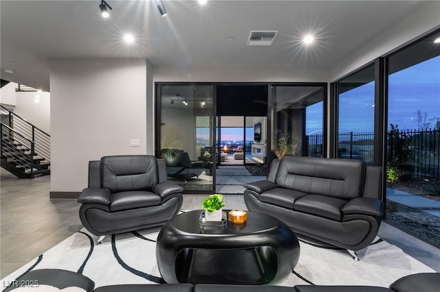 living room with stairs and visible vents