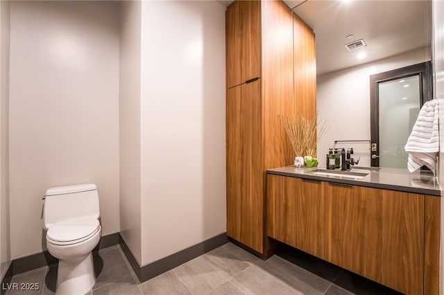 bathroom featuring baseboards, visible vents, toilet, tile patterned floors, and vanity