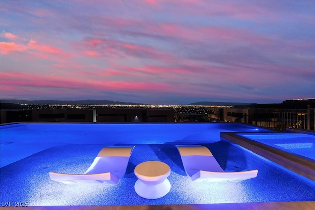 view of pool with a pool with connected hot tub and a mountain view