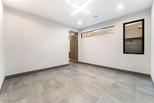 spare room featuring baseboards, visible vents, and recessed lighting