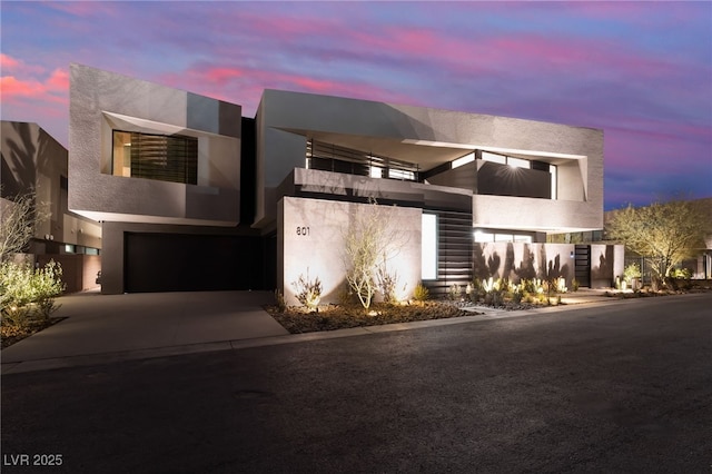 modern home featuring driveway, stucco siding, and an attached garage