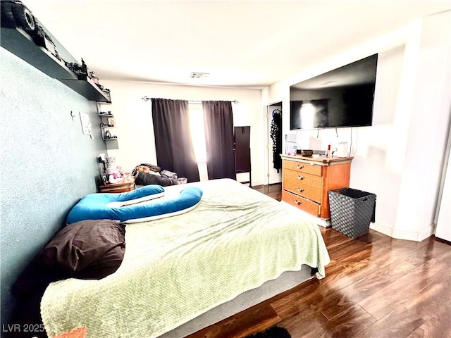 bedroom with dark wood-type flooring, visible vents, and baseboards