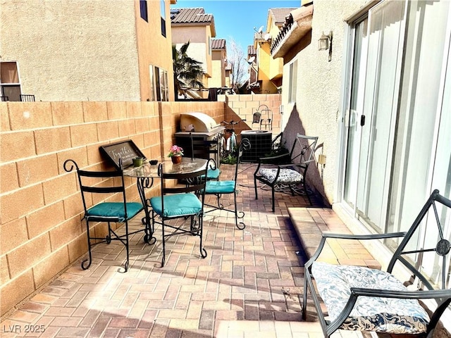 view of patio featuring outdoor dining area, cooling unit, fence, and a grill