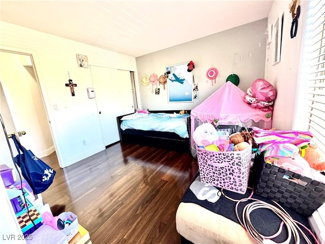 bedroom with baseboards, dark wood finished floors, and a closet