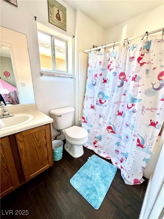 bathroom featuring a shower with shower curtain, vanity, toilet, and wood finished floors