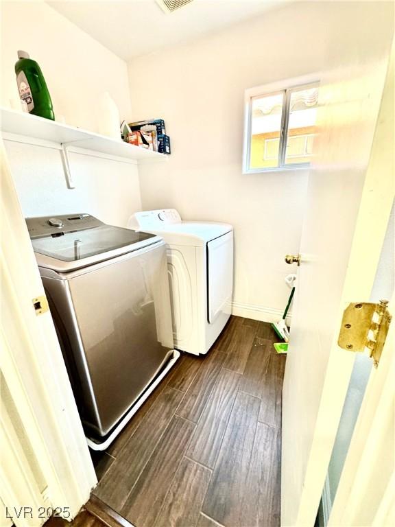 clothes washing area featuring laundry area, visible vents, baseboards, independent washer and dryer, and wood tiled floor