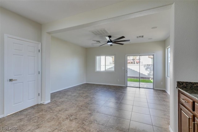 unfurnished room featuring a ceiling fan, visible vents, and baseboards