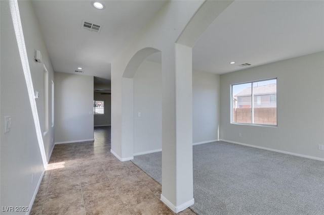 spare room featuring visible vents, arched walkways, and recessed lighting