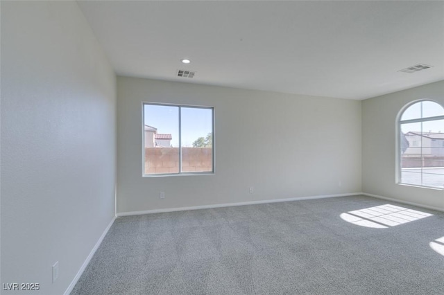 unfurnished room with carpet, visible vents, baseboards, and recessed lighting