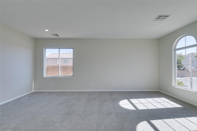 spare room with baseboards, visible vents, and a wealth of natural light