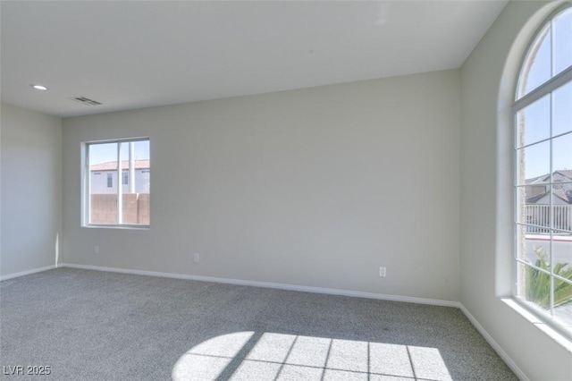 spare room with light carpet, recessed lighting, visible vents, and baseboards