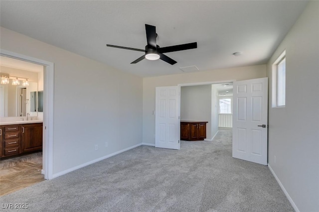 unfurnished bedroom featuring light carpet, ceiling fan, ensuite bath, and baseboards