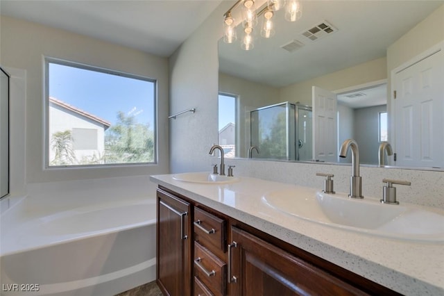 bathroom with double vanity, a garden tub, a sink, and a stall shower