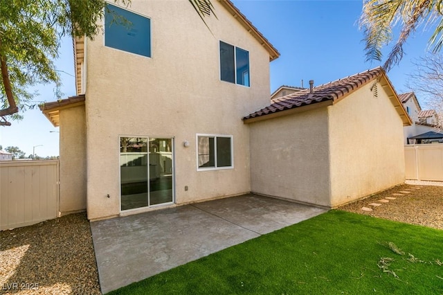 rear view of property with a patio area, fence, a tiled roof, and stucco siding