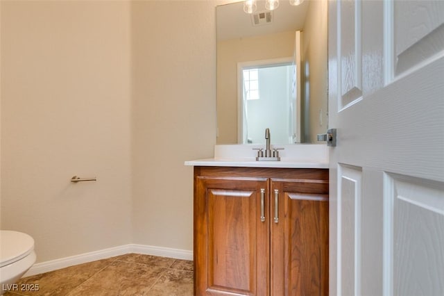 bathroom with tile patterned flooring, toilet, vanity, visible vents, and baseboards