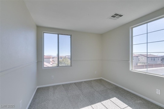 carpeted empty room with baseboards and visible vents