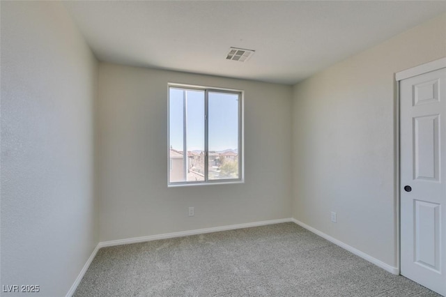 empty room with carpet flooring, visible vents, and baseboards