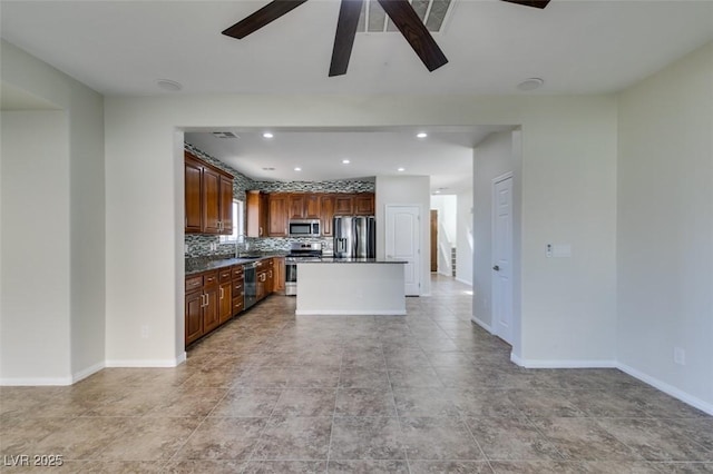 kitchen with tasteful backsplash, dark countertops, a kitchen island, open floor plan, and stainless steel appliances