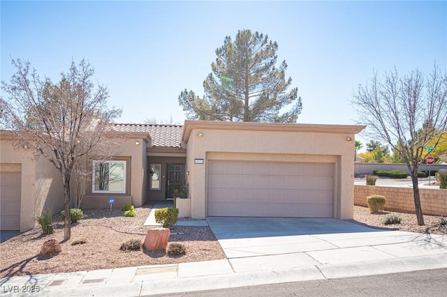 view of front of property with a garage, concrete driveway, a tile roof, and stucco siding