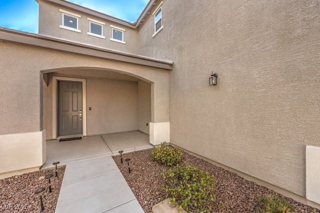 view of exterior entry featuring stucco siding